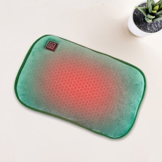 Coussin vert chauffant sur une table blanche à coté d'une plante