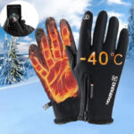 gant de ski noir chauffant sur un fond de neige