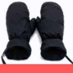 gants noir chauffant pour le ski poser sur un fond blanc