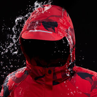 Manteau chauffant et résistant aux intempéries pour hommes de couleur rouge sous une pluie sur un fond noir