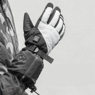 Homme portant des gants de moto gris chauffants sur un fond gris