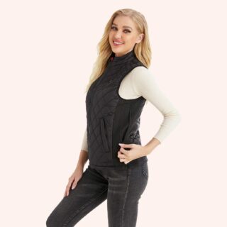 Blouson sans manche noir porté par une femme blonde sur un fond beige