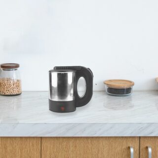 Sur un plan de travail de cuisine moderne en marbre blanc et en bois, on voit un mug chauffant solide en acier inoxydable. Près de lui, un bocal de céréales.