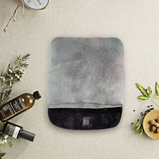 Chauffe pied gris et noir avec des feuilles et des bouteilles autour.