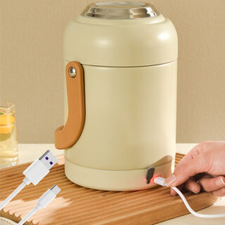 On voit un tupperware chauffant beige très élégant en forme cylindrique. Une main est en train de le brancher pour l'actionner.