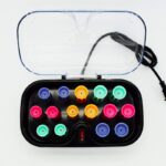 On voit des bigoudis chauffants dans leur boîte chauffante. Les bigoudis sont de toutes les couleurs.