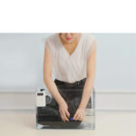 femme qui met dans l'eau le gilet chauffant noir