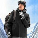 homme qui porte le blouson chauffant avec batterie dans les montagnes