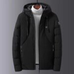 blouson noir chauffant avec batterie poser sur un mannequin.